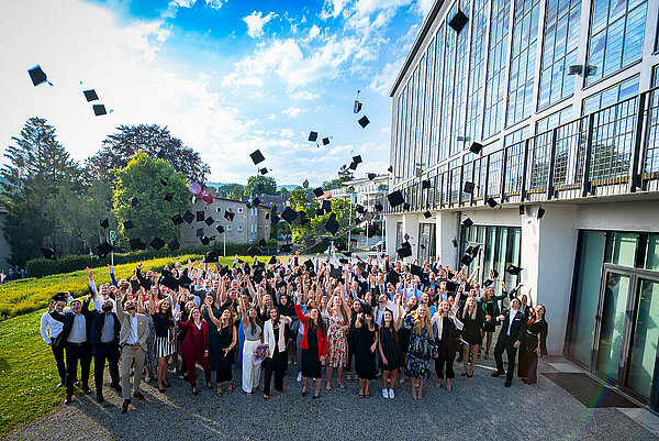 Absolventen werfen Hüte in die Luft
