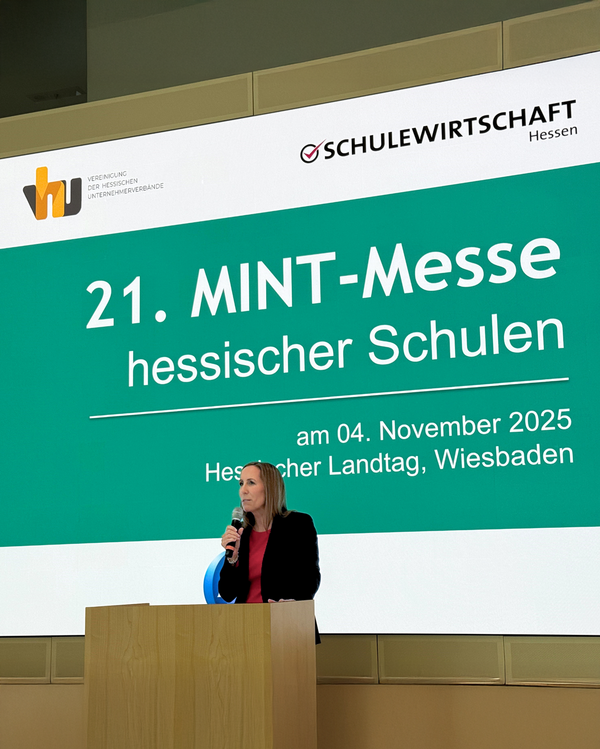 Hessische Landtagspräsidentin Astrid Wallmann steht an einem Rednerpult mit Mikrofon vor einer großen Leinwand. Die Leinwand zeigt den Schriftzug „21. MINT-Messe hessischer Schulen“ sowie Datum und Ort: 4. November 2025, Hessischer Landtag, Wiesbaden.
