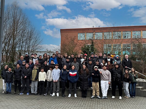 Gruppe von Schülern und Lehrern im Freien.