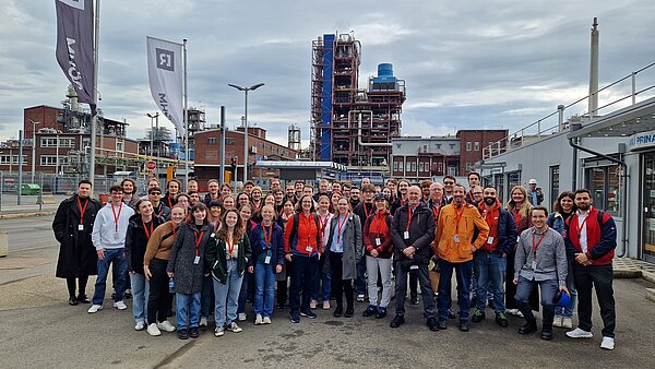 Gruppenfoto vor Industriekulisse.