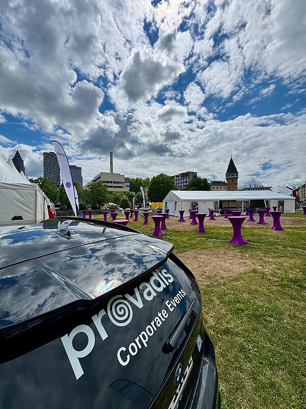 Eventfläche mit Auto und Wolken im Hintergrund Auto mit Logo auf einer Eventfläche