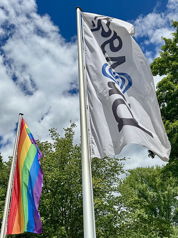 Links weht eine Regenbogenflagge, rechts eine Provadis Flagge nebeneinander