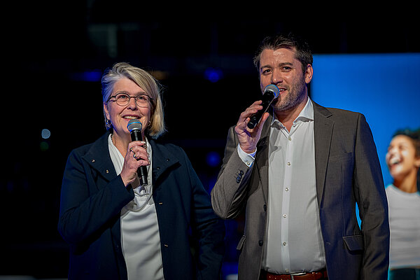 zwei Redner mit Mikrofon auf der Bühne bei der Absoventenfeier
