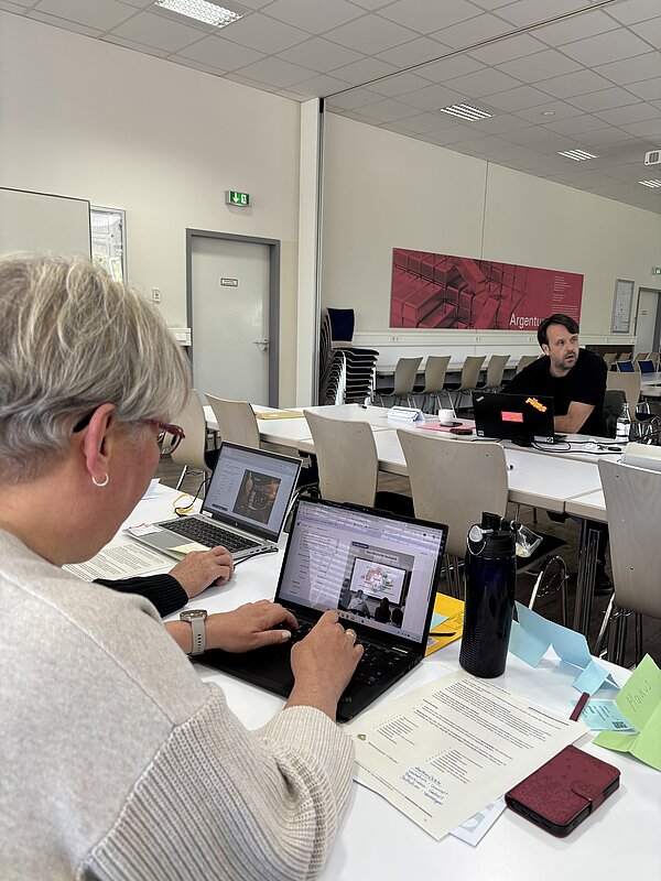 Person tippt auf Laptop in Besprechung.