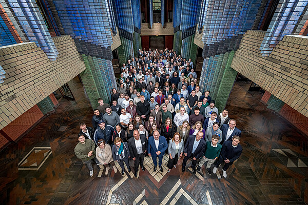 Das Team versammelt in einem historischen Gebäude Gruppenfoto in einem bunten Raum