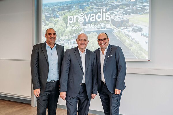 Feierlicher Abschied und Staffelübergabe Drei Personen in Business-Outfits stehen vor der Leinwand mit dem Schriftzug „Provadis – Goodbye Udo Lemke“ zusammen, symbolisch für den Führungswechsel bei Provadis und die Zusammenarbeit mit Infraserv Höchst.