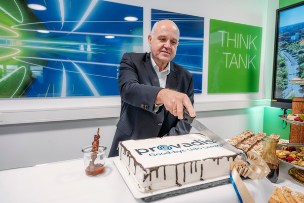 Abschiedstorte Dr. Udo Lemke schneidet eine rechteckige Torte mit Provadis-Logo und der Aufschrift „Goodbye Udo Lemke“ an, auf einem Tisch mit Dessertbuffet im Hintergrund.