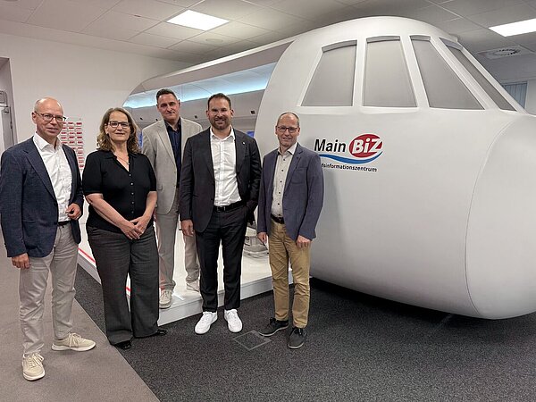 Gruppenfoto vor einem Flugzeugmodell.